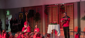 Der Nikolaus und am boden sitzende Kinder singen